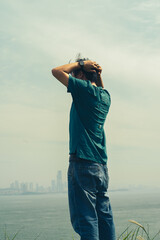 Man standing in contemplation on the shore of desolate beach