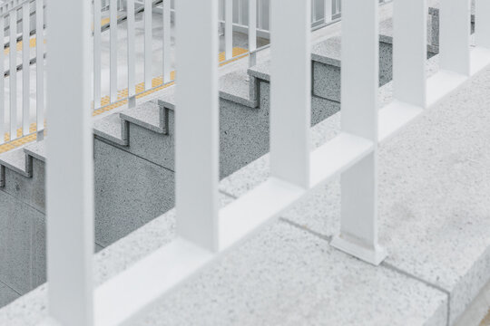 Stairs seen through white railings.