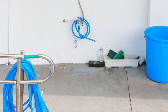 Blue hose and blue bucket next to the faucet.