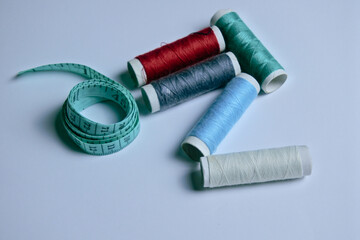spools of thread and sewing tape measure isolated in white background