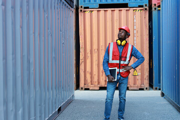 Foreman using tablet and walkie talkie radio control loading containers box. Engineer or worker with safety hat work at container cargo site and checking industrial container cargo freight ship.