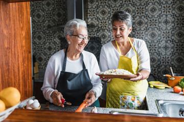 Hispanic women grandmother and daughter cooking at home kitchen in Mexico Latin America