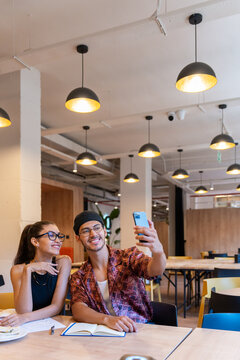 Brunette Man And Woman Taking A Selfie In A Modern Office.