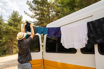 Man doing laundry by hand in camper van in nature