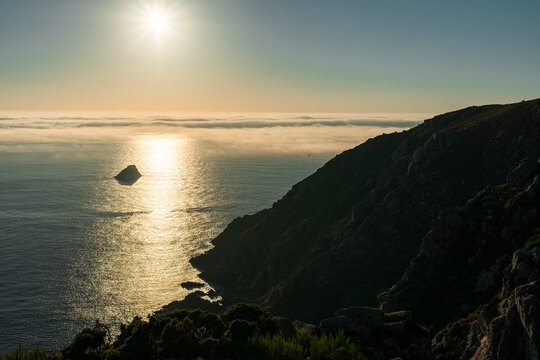 Sailboat sailing at sunset along Finisterre Cape, Atlantic Ocean 