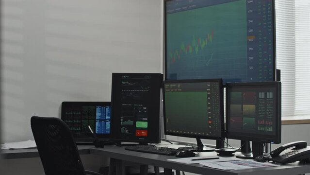 Horizontal no people shot of stock and currency trading agents workspace with desktop computer monitors in modern office interior