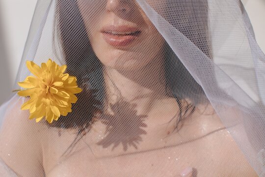 Anonymous woman with juicy lips under veil with flowers