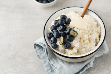 Rice milk porridge with blueberries in a bowl close-up. The concept of a healthy and tasty breakfast.