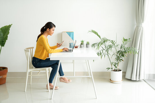 Happy satisfied woman working online using laptop in new modern