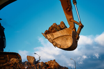 Scoop of building excavator full of concrete stone leftovers