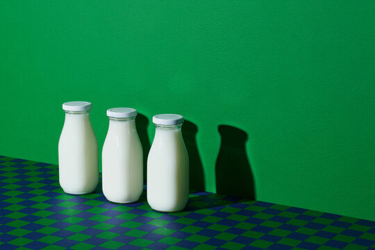 Three glass bottle of milk on the checkered table