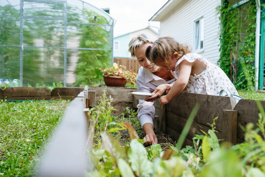 Mom and daughter plant seeds in the garden