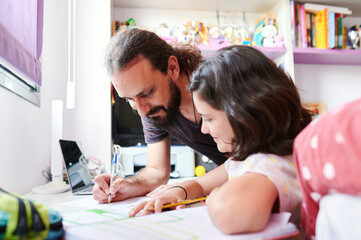 Dad helping his daughter do homework