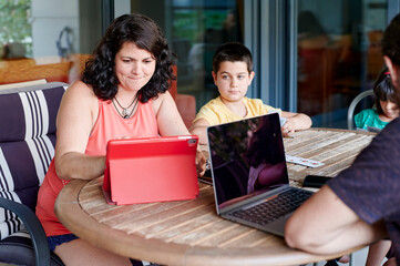 Parents working from home outside with their children