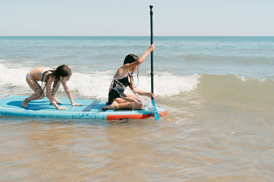 Girls with inflatable kayak by the sea