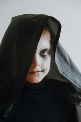 Scary boy celebrating halloweenday of the dead terrifying skull face makeup for eyes mouth