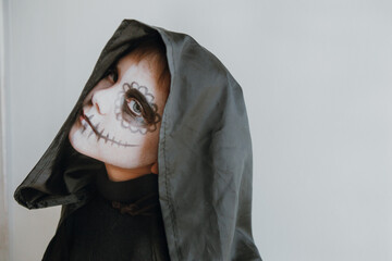 Scary boy celebrating halloweenday of the dead terrifying skull face makeup for eyes mouth