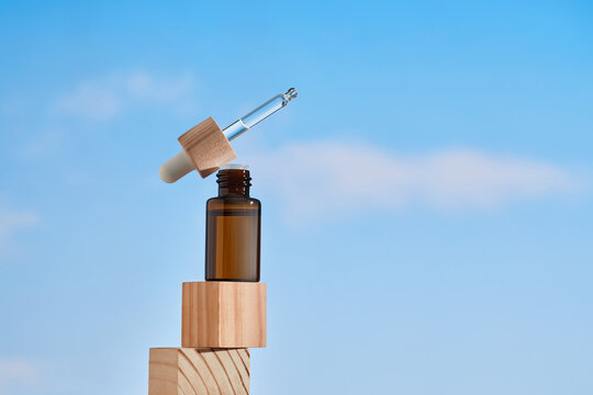 A bottle of essential oil and zen stones against a background