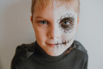 Scary boy celebrating halloweenday of the dead terrifying skull face makeup for eyes mouth