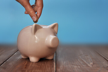 A man throws money into a piggy bank, a symbol of money accumulation