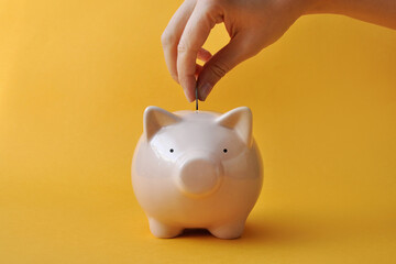 A man throws money into a piggy bank, a symbol of money accumulation