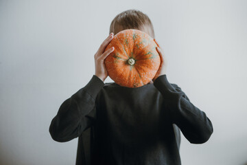 Scary boy holds pumpkins for halloween celebration