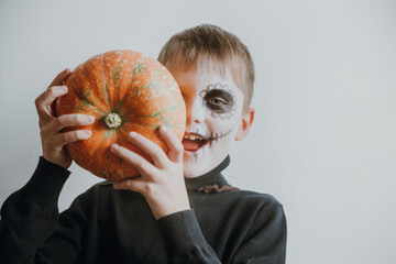 Scary boy holds pumpkins for halloween celebration