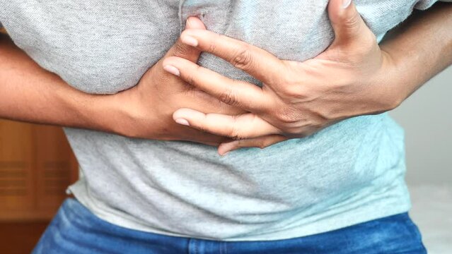 young man suffering pain in heart and holding chest with hand 