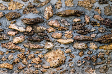 Old style wall made of rough stones with cement. Ancient grunge stones wall backdrop. Background of old vintage wall.Ancient style stone fence decoration to be beautiful and strong with natural stone.