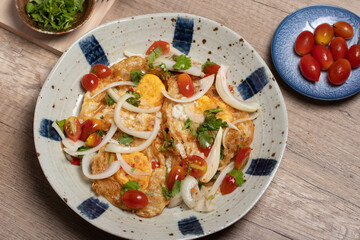 Spicy fried egg salad with vegetables, tomatoes, onions