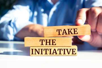 Wooden blocks with words 'Take the Initiative'.