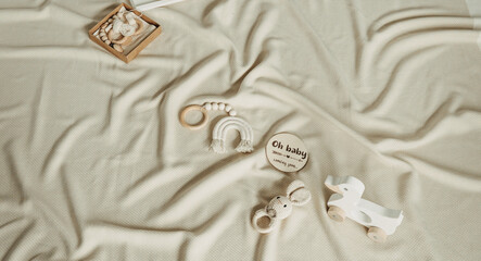 Set of newborn stuff and baby accessories. Cute shoes, wood toys on beige background. Baby shower,...