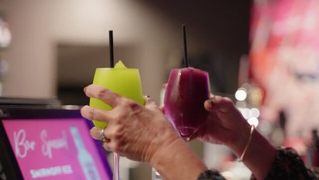 4K Slow Motion Bartender Placing Straws Into Frozen Daiquiri Cocktails At Busy Bar
