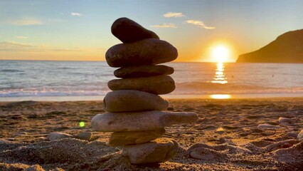 Stones pyramid on the beach at sunset (