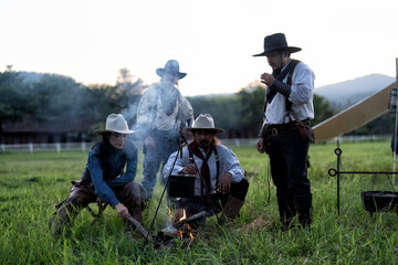 Cowboy groups stopped camping and rest and brewed coffee on 3 legs steel support hanging kettle...