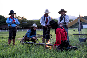 Cowboy groups stopped camping and rest and brewed coffee on 3 legs steel support hanging kettle...