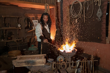 Cowboy steel farrier hoseshoe maker in the shop burn red hot steel piece in the fire blower stove...