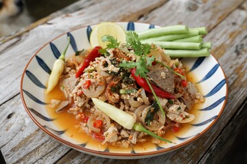 Spicy minced pork salad served with fresh vegetables  Minced pork salad is a popular traditional Thai food of Thailand.  Spicy Minced Pork Salad is also called Larb Moo.