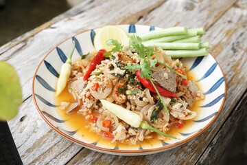 Spicy minced pork salad served with fresh vegetables  Minced pork salad is a popular traditional Thai food of Thailand.  Spicy Minced Pork Salad is also called Larb Moo.