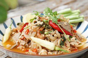 Spicy minced pork salad served with fresh vegetables  Minced pork salad is a popular traditional Thai food of Thailand.  Spicy Minced Pork Salad is also called Larb Moo.