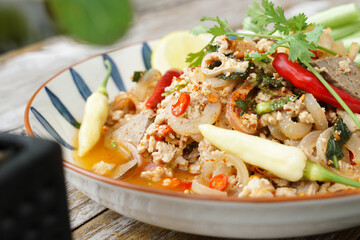 Spicy minced pork salad served with fresh vegetables  Minced pork salad is a popular traditional Thai food of Thailand.  Spicy Minced Pork Salad is also called Larb Moo.