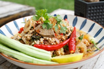 Spicy minced pork salad served with fresh vegetables  Minced pork salad is a popular traditional Thai food of Thailand.  Spicy Minced Pork Salad is also called Larb Moo.