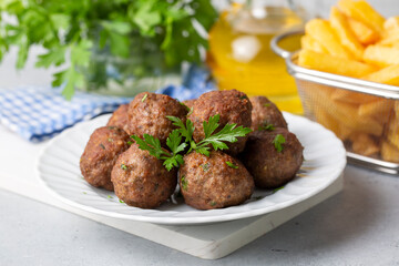 Round shaped balls of dry meatballs and french fries. Turkish name; kuru kofte ve patates