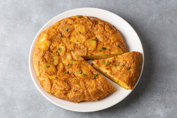 Spanish omelette with potatoes, typical spanish cuisine on gray concrete floor. Tortilla Espanola. Turkish name; Yumurtali patates