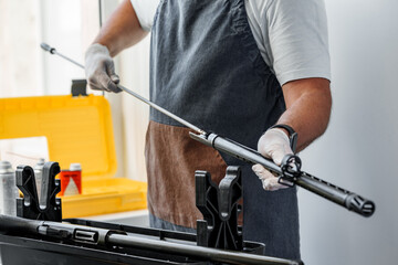 Close up of a gunsmith cleaning firearm barrel with ramrod brush - obrazy, fototapety, plakaty