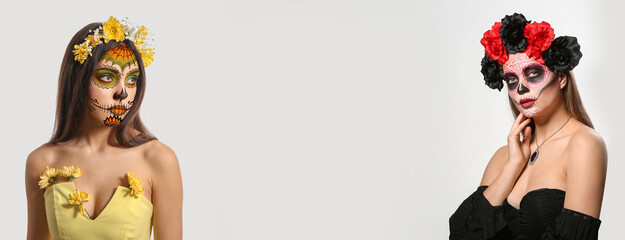 Young woman with painted skull on her face for Mexico's Day of the Dead against white background