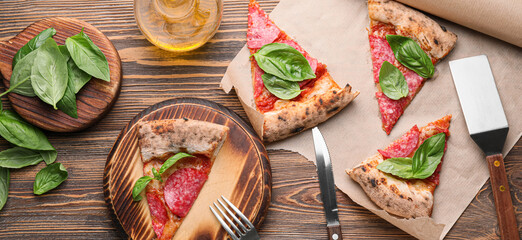 Composition with slices of tasty pizza on wooden table, top view