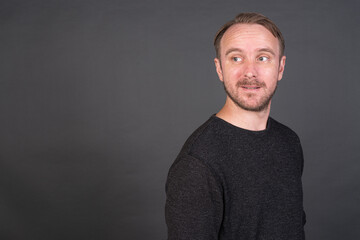 Studio portrait of blonde Caucasian man against gray background