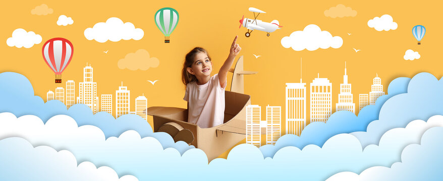 Little girl with cardboard airplane flying in drawn sky