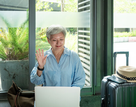 relax, vacation, travel, portrait of senior adult elderly asian woman 60s smiling using the computer laptop while waiting for her travel time.